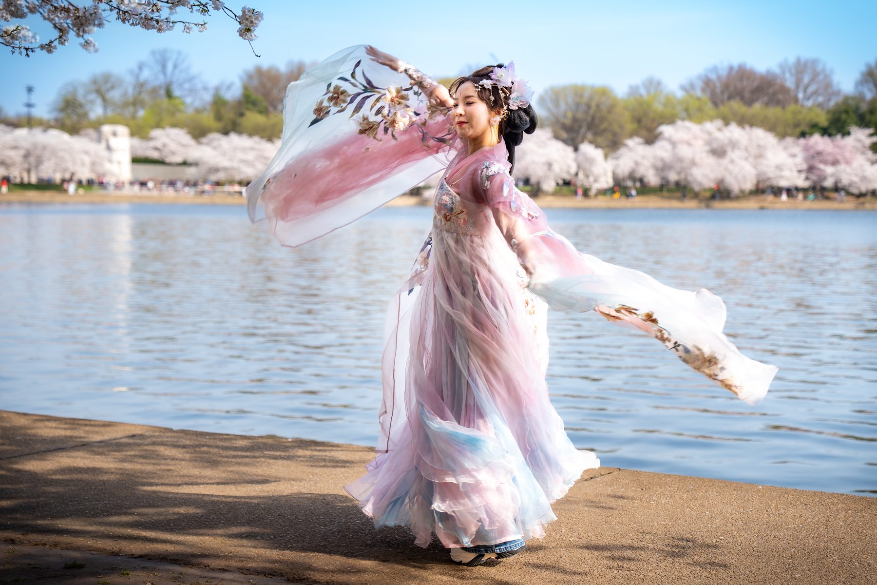 Portrait in a pink dress near cherry blossoms